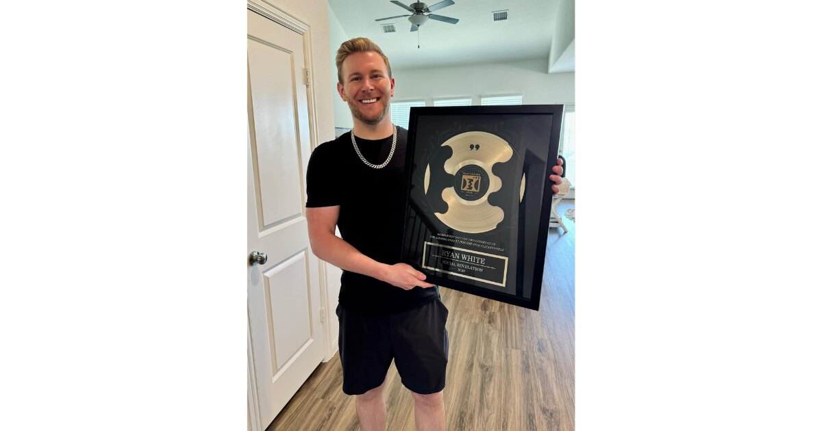 Entrepreneur Ryan White, founder of Social Revelation, holding his ClickFunnel's Two Comma Club Award