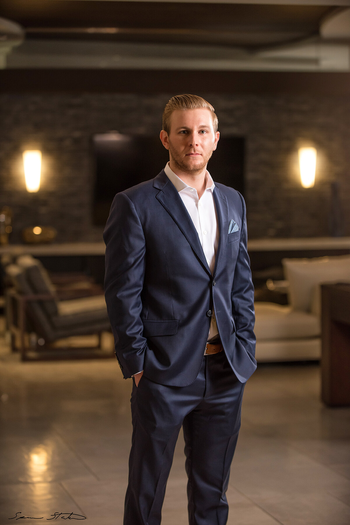 Entrepreneur Ryan White, founder of Social Revelation, standing in a blue suit in a modern living room