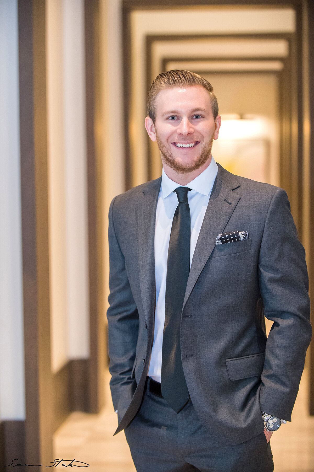 Entrepreneur Ryan White, founder of Social Revelation, smiling in a gray suit in a long hallway